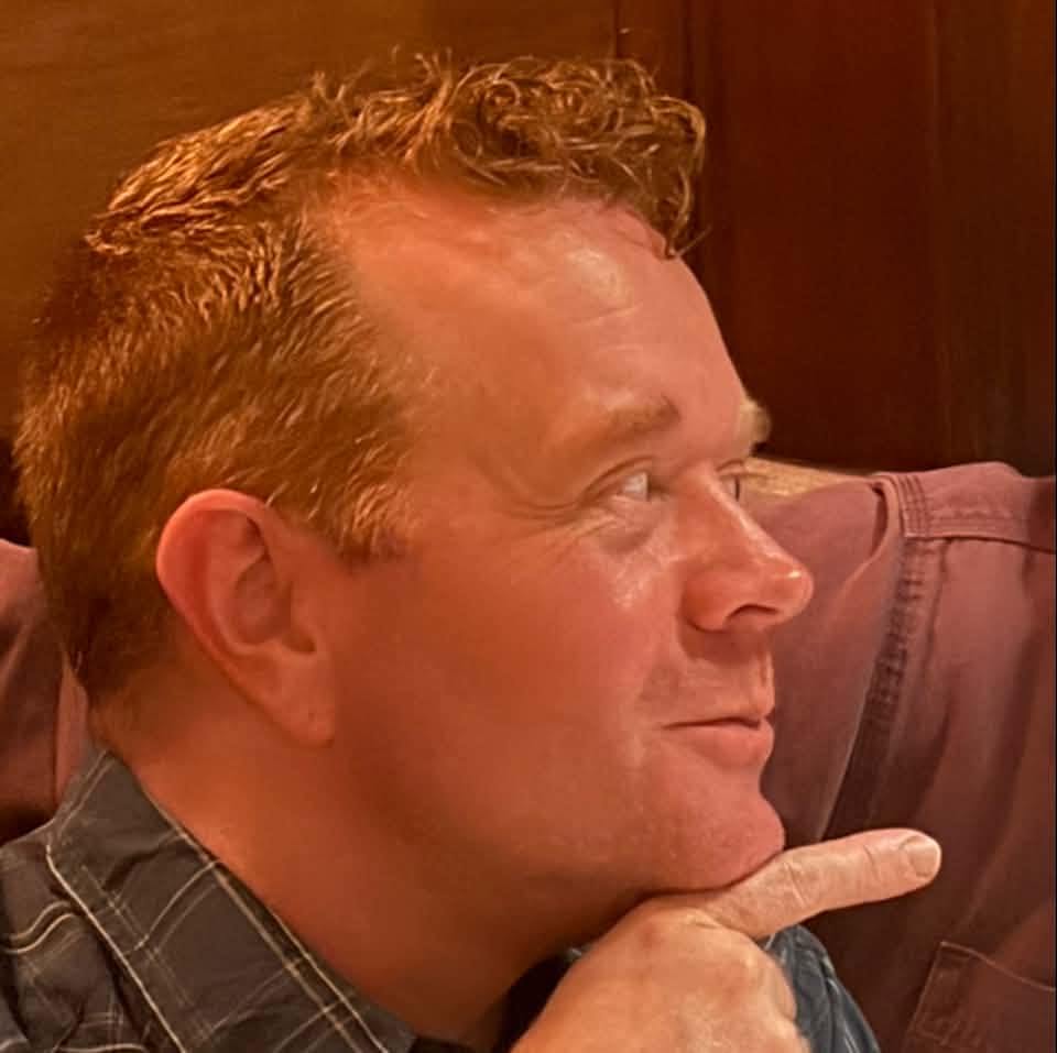 Adam Schricker in profile, chin resting on his hand