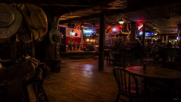 A Texas honky-tonk stage with neon and a steel guitar.